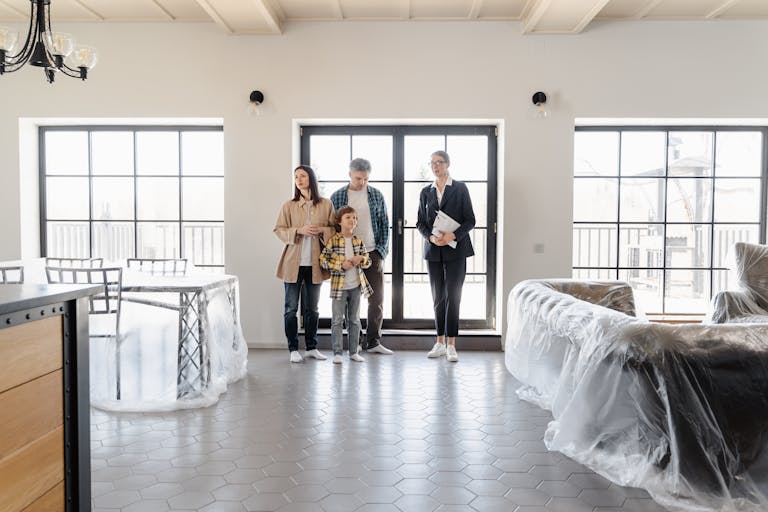Family explores new home with agent, highlighting modern interiors.